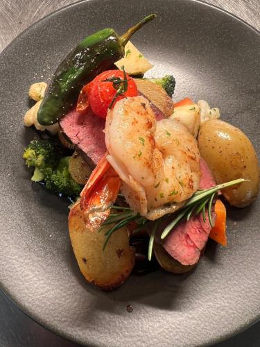 a plate of food with shrimp and potatoes and vegetables at Hotel Gasthof zum Wulfen in Sulzbach-Rosenberg