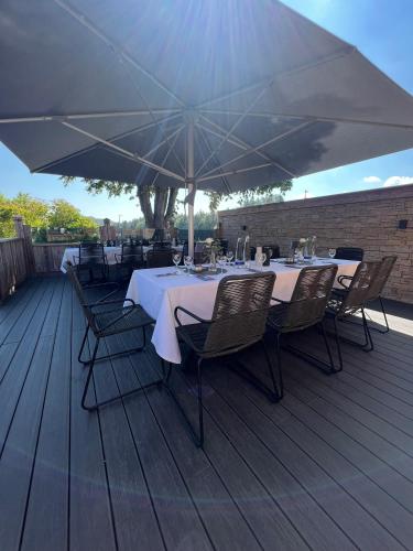 a table and chairs on a deck with an umbrella at Hotel Gasthof zum Wulfen in Sulzbach-Rosenberg