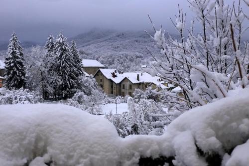 a snow covered yard with a house in the background at Hotel Pian del Sole in Sassello