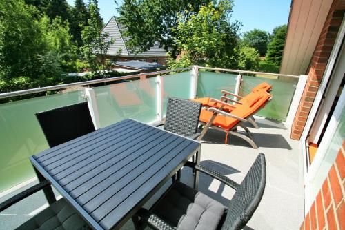 a patio with a table and chairs on a balcony at Ferienwohnungen Wyk/Föhr in Wyk auf Föhr