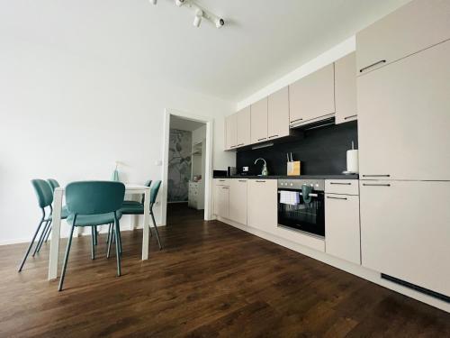 a kitchen with white cabinets and a table and chairs at APSTAY Eggenberg I Self Check-in I Parking option in Graz