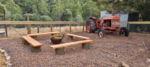 an old tractor and benches in front of a truck at Wally's Edge 20acre Farm Stay in Rawson