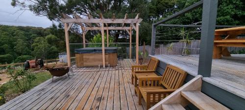 une terrasse en bois avec deux chaises et un kiosque dans l'établissement Wally's Edge 20acre Farm Stay, à Rawson