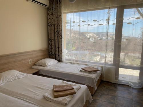 バルチクにあるVilla Elinaの大きな窓付きの客室で、ベッド2台が備わります。