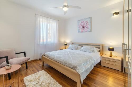 ein weißes Schlafzimmer mit einem Bett und einem Sofa in der Unterkunft Peters apartment in Sutivan