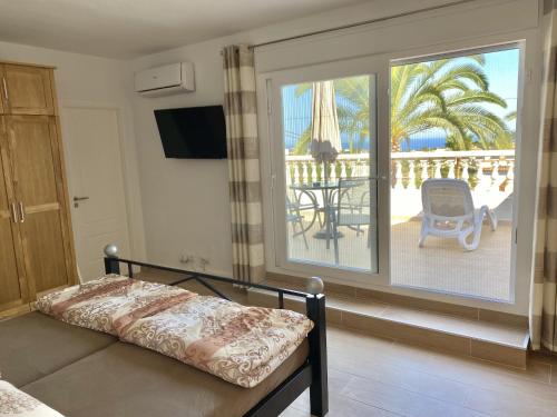 1 Schlafzimmer mit einem Bett und einem Balkon mit einem Tisch in der Unterkunft Villa Emilia 8 PAX in Calpe
