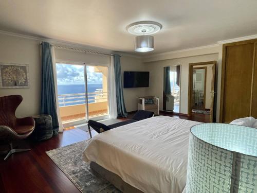 een slaapkamer met een bed en uitzicht op de oceaan bij All Warmth - Colinas do Lido in Funchal