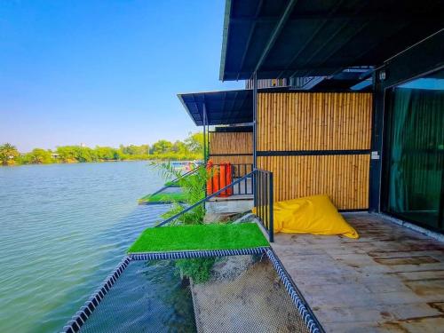 a building with a view of a body of water at Kram Farmstay in Nakhon Pathom