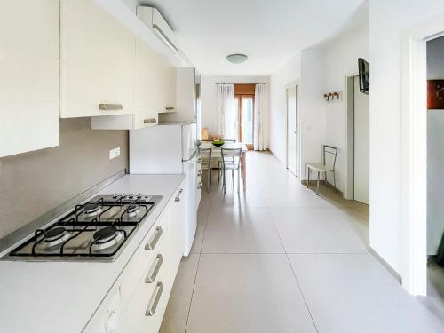 una cucina con armadi bianchi e piano cottura di Jesolo Sun Beach House - Host Solution a Lido di Jesolo