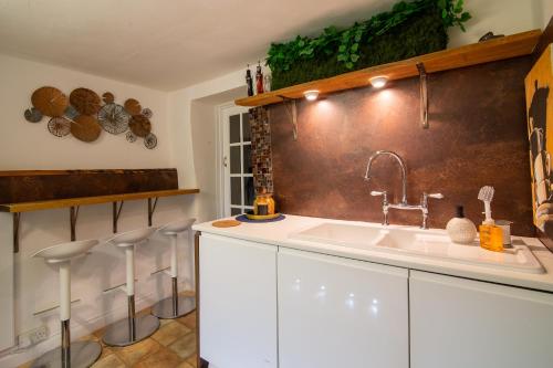 a kitchen with a sink and some stools at PRIVACY Entire BARN for 4 Garden Cliff Vobster Quay Frome Longleat Bath Stonehenge BBQ HQ & Pet FREE-ndly in Radstock