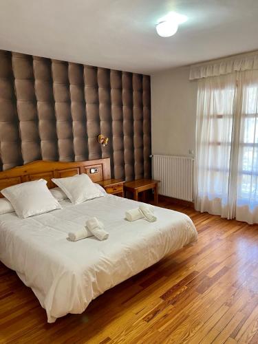 ein Schlafzimmer mit einem großen Bett, auf dem zwei Handtücher liegen in der Unterkunft Hotel Eriste in Eriste