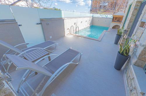 um pátio com 2 cadeiras e uma piscina em Villa Nuelle em Tílisos