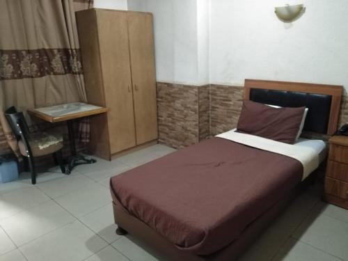 a bedroom with a bed and a desk and a desk at Amman Palace Hotel in Amman