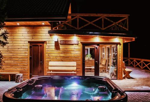 a hot tub in front of a log cabin at Gerovės sodybėlė in Garliava