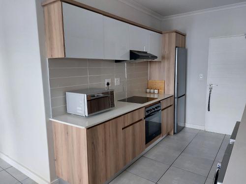 a small kitchen with a microwave and a refrigerator at The Blyde Penthouse in Pretoria