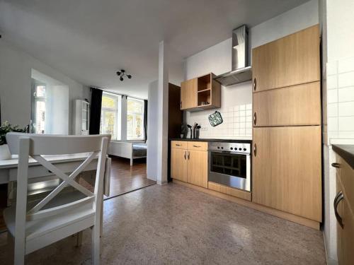 a kitchen with wooden cabinets and a white chair in it at R&L Apartment Karl-Heine-Strasse OG in Leipzig
