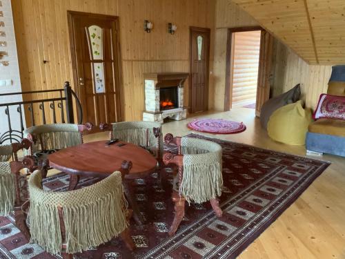 a living room with a table and chairs and a fireplace at Гостьовий двір РіОНІ in Truskavets