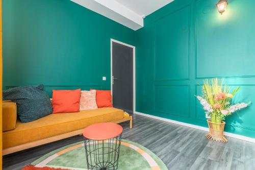 a living room with green walls and a couch at Le Selah in Tourcoing