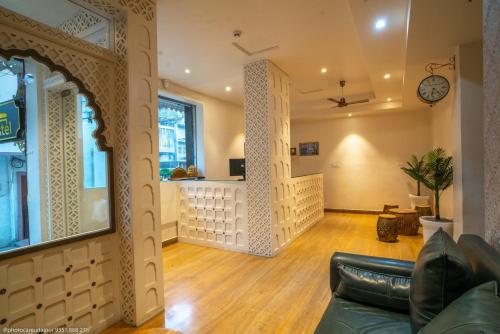 a living room with a couch and a clock on the wall at The Uddhav Elite in Udaipur