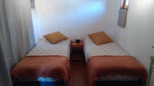 two twin beds in a small room with a table at Les hirondelles in Wangen