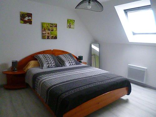 une chambre avec un lit et une lucarne dans l'établissement gite au calme centre finistère jardin clos, à Trégourez