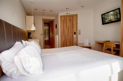 a bedroom with a large white bed with white pillows at Elements Rooms & Apartments in Athens