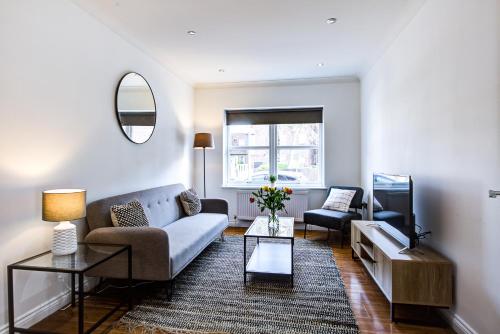 uma sala de estar com um sofá e uma televisão em Stylish Two Bedroom Apartment With Free Parking! em Romford