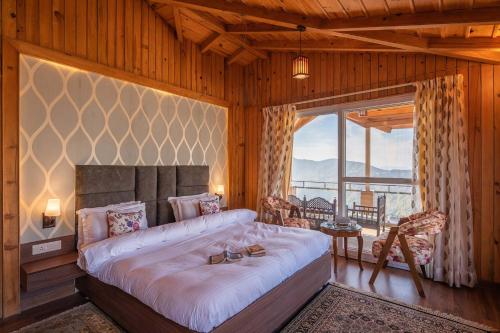 a bedroom with a large bed and a large window at Wilderness Whisperings by VEO - Part of StayVista in Nainital