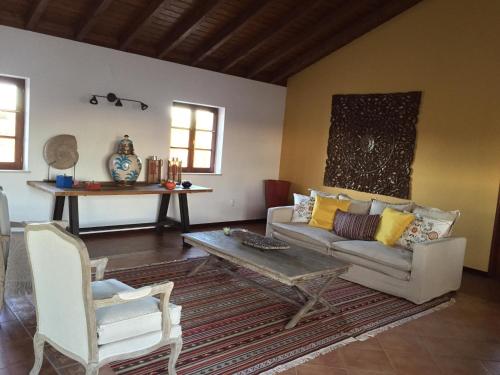 a living room with a couch and a table and chairs at Refúgio do Monte in Odemira