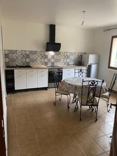 - une cuisine avec une table, une table et des chaises dans l'établissement Chez Cathy et Philippe, à Vérargues