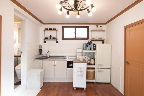 kuchnia z białymi szafkami i lodówką w obiekcie Stay Hwangchon w mieście Gyeongju