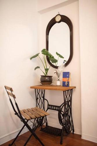 a table with a mirror and a chair and a table with a plant at Stay Hwangchon in Gyeongju