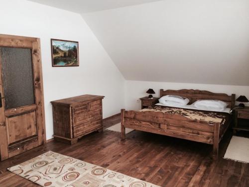 a bedroom with a bed and a dresser and a door at Chata Vločka - Orava Snow v lyžiarskom stredisku in Oravská Lesná