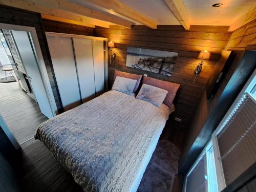 1 dormitorio con 1 cama en una pared de madera en Tiny House Flensburg Lee en Handewitt