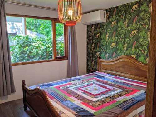 a bedroom with a bed with a quilt on it at Sfeervol chaletje in een rustige bosrijke omgeving in Diessen