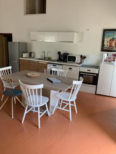 a kitchen with a table and chairs and a kitchen with a refrigerator at La Maison BellecOur in Vaudelnay