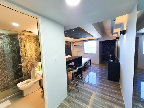 a bathroom with a toilet and a sink and a bathroom with a shower at Burgundy McKinley Place Service Apartment in Manila