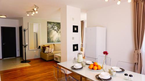 een keuken en een woonkamer met een tafel en stoelen bij Byala Cliff Sea View Penthouse in Byala