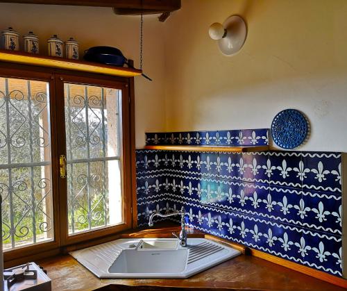 cocina con azulejos azules y blancos y fregadero en La Tinaia, en Bosa Marina