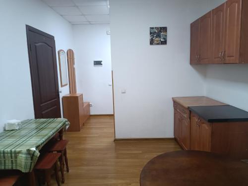 - une cuisine avec des placards en bois, une table et des chaises dans l'établissement Apartments Domovik on Valenberga 3, à Moukatcheve