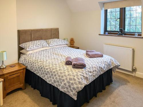 a bedroom with a bed with two towels on it at Lavender Cottage in Stretton on Fosse