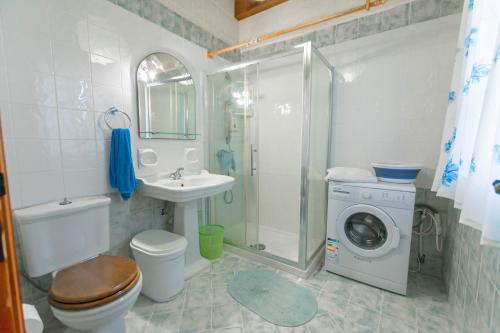 a bathroom with a shower sink and a washing machine at Stunning 3 bedroom Farmhouse with pool in Xagħra