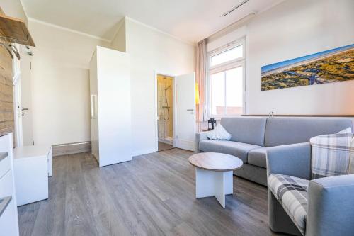 een woonkamer met een bank en een tafel bij Haus Inselanker Kajüte 05 in Norderney