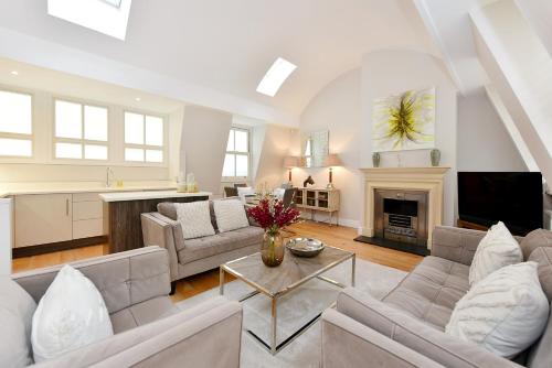 a living room with white furniture and a fireplace at London Choice Apartments - South Kensington - Mews House II in London