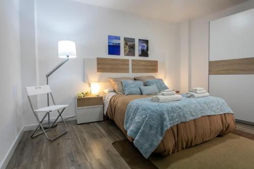 1 dormitorio con cama, lámpara y silla en Apartamento renovado y confortable en el centro de Granada, en Granada