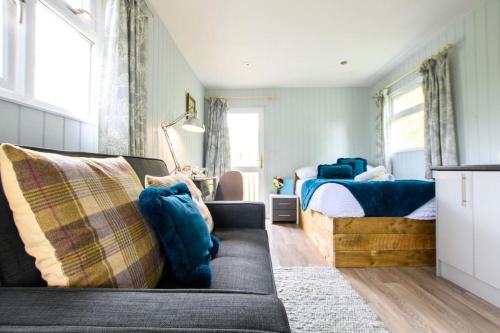 a bedroom with a couch and a bed at Lakeside Cabin on Stilts- 'Kingfisher' in Rous Lench