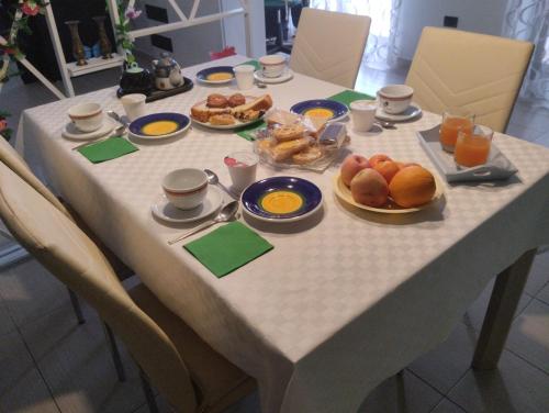 una mesa con alimentos para el desayuno y zumo de naranja en ella en B&B Angolo Verde, en Terni