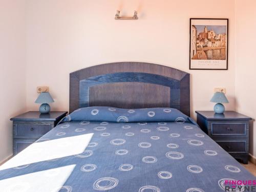 a bedroom with a blue bed with two night stands at Carabela 1º3ª in Sant Feliu de Guíxols