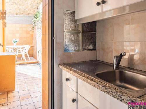 a kitchen with a stainless steel sink and a table at Carabela 1º3ª in Sant Feliu de Guíxols