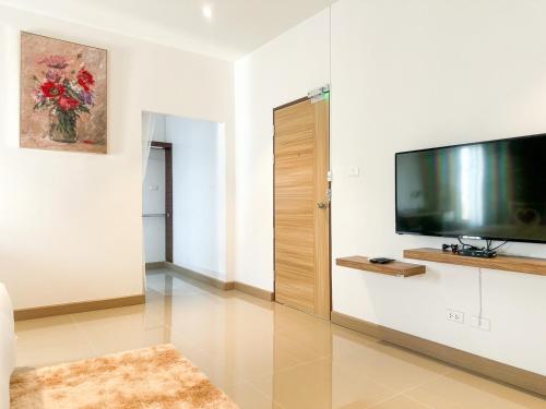 a living room with a flat screen tv on a wall at Happy Land Residence in Ban Nam Cham